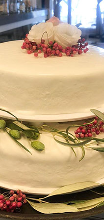 Two-story wedding cake decorated with olive leaves